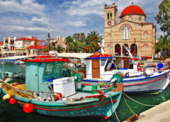 Aegina recibe a los viajeros con su encantador puerto, coloridos barcos pesqueros y el auténtico ambiente de una isla griega.